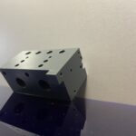 Bloc souffleur en PVC gris usiné pour machine spéciale avec perçages multiples