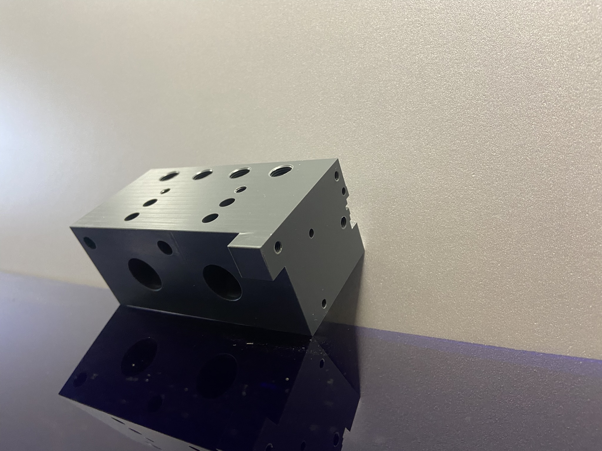 Bloc souffleur en PVC gris usiné pour machine spéciale avec perçages multiples